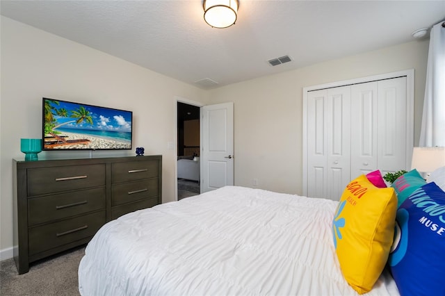 bedroom featuring a closet, light carpet, and a textured ceiling