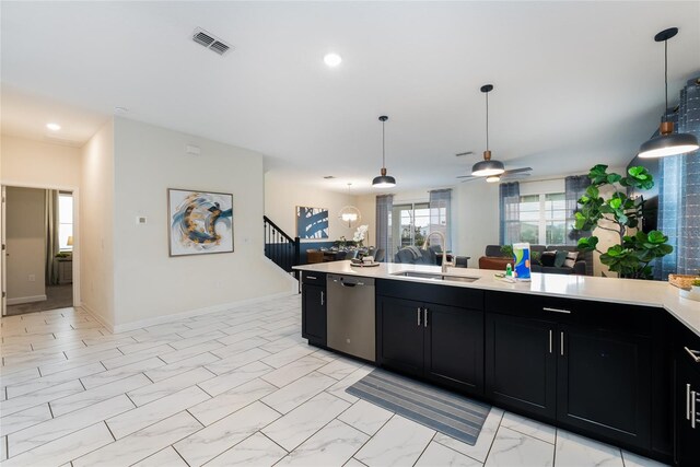 8896 Cabot Cliffs Dr, Davenport, FL 33896 - kitchen with stainless steel dishwasher, a sink, dark cabinetry, light countertops, and a ceiling fan