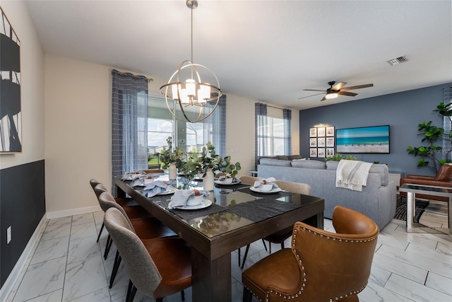 dining space featuring ceiling fan with notable chandelier