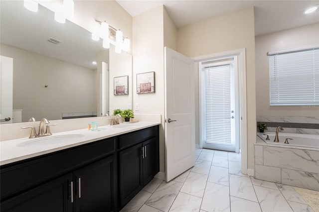 bathroom featuring vanity and a relaxing tiled tub