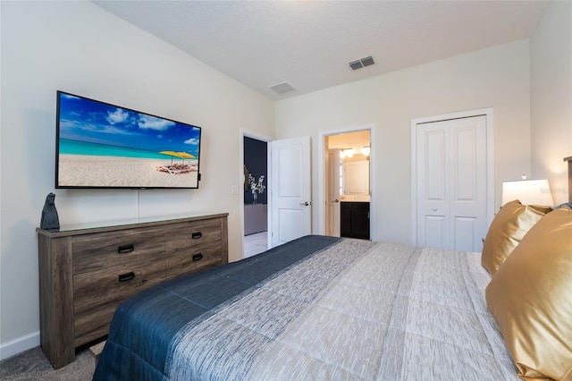 carpeted bedroom featuring ensuite bathroom and a closet