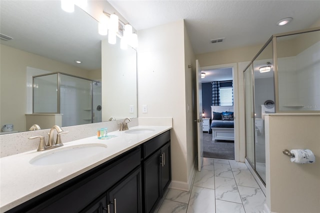 bathroom with vanity, an enclosed shower, and a textured ceiling