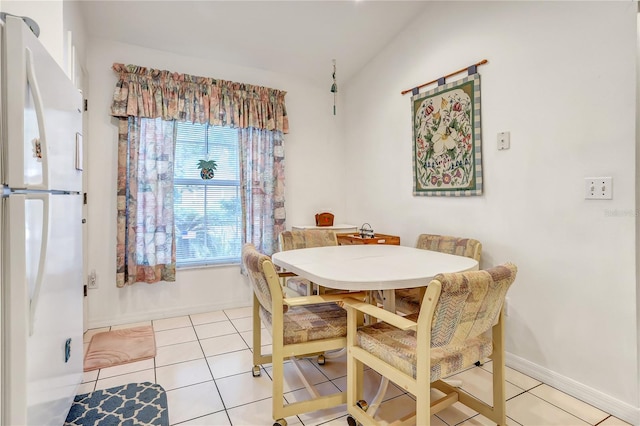 dining space featuring lofted ceiling and light tile patterned flooring