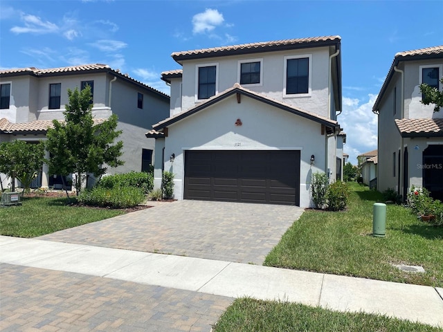 mediterranean / spanish house featuring a front yard, central AC, and a garage