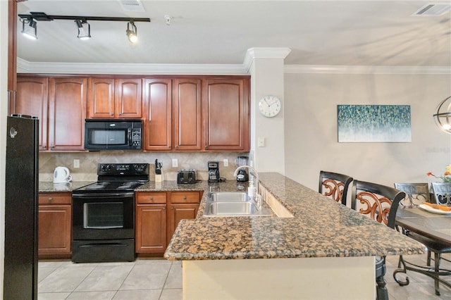 kitchen featuring decorative backsplash, dark stone counters, ornamental molding, black appliances, and sink