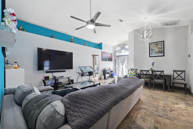 living room featuring vaulted ceiling and ceiling fan with notable chandelier