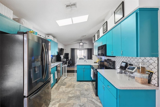 kitchen with black appliances, ceiling fan, vaulted ceiling with skylight, blue cabinetry, and decorative backsplash