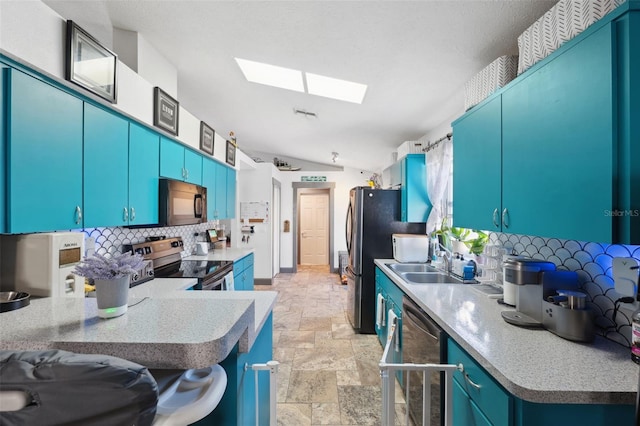 kitchen with kitchen peninsula, backsplash, stainless steel appliances, lofted ceiling with skylight, and blue cabinets