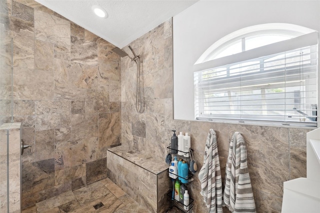 bathroom with a textured ceiling, tile walls, vaulted ceiling, toilet, and tiled shower