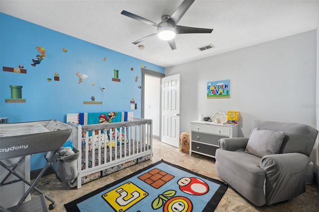 bedroom with a nursery area and ceiling fan