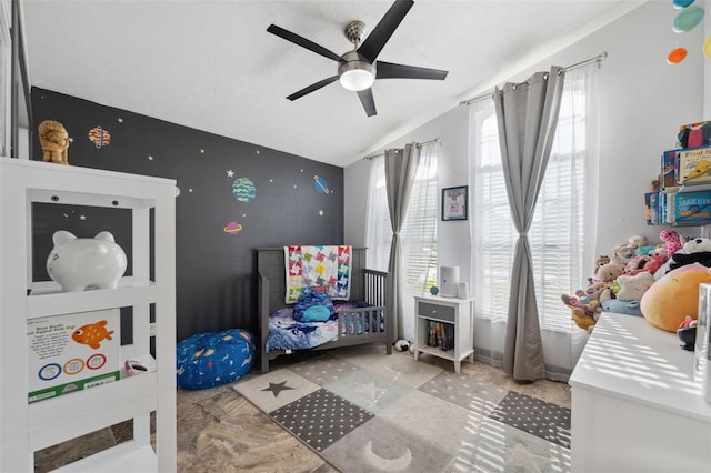 bedroom with vaulted ceiling, a textured ceiling, and ceiling fan