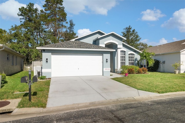 ranch-style home featuring a garage, stucco siding, and a front yard
