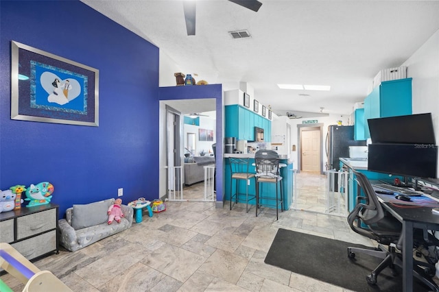 office area with stone tile floors, ceiling fan, and visible vents