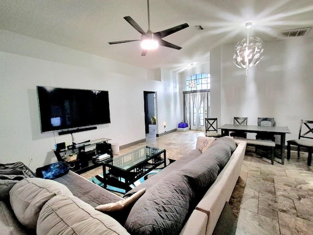 7940 Fashion Loop, New Port Richey, FL 34654 - living room featuring stone tile flooring, a high ceiling, ceiling fan, and a chandelier