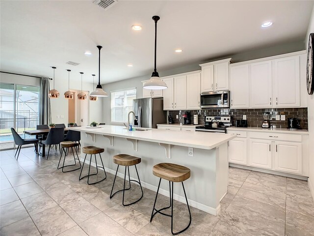 1861 Sawyer Palm Pl, Kissimmee, FL 34747 - kitchen featuring appliances with stainless steel finishes, decorative backsplash, a large island, a kitchen breakfast bar, and a sink
