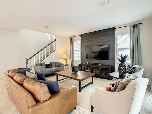 1861 Sawyer Palm Pl, Kissimmee, FL 34747 - living area featuring stairway, plenty of natural light, and an accent wall