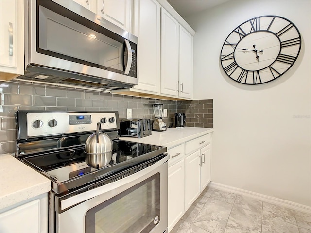 kitchen with decorative backsplash, appliances with stainless steel finishes, and white cabinetry