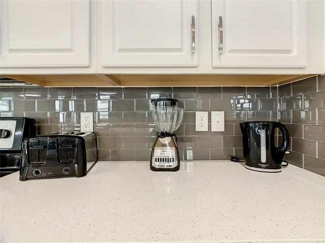 1861 Sawyer Palm Pl, Kissimmee, FL 34747 - kitchen view of white cabinets, decorative backsplash, and light stone counters