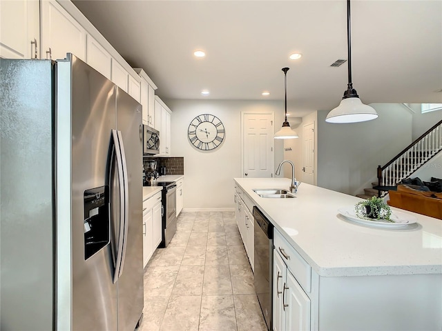 kitchen featuring sink, appliances with stainless steel finishes, decorative light fixtures, and white cabinetry