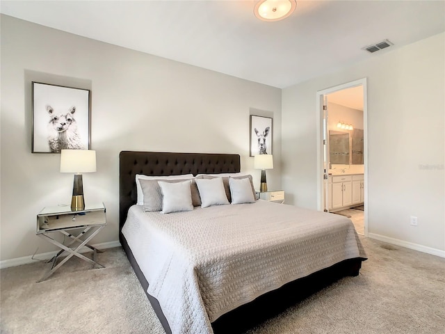 bedroom featuring light colored carpet and connected bathroom