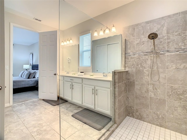 bathroom featuring vanity, tile patterned floors, and tiled shower