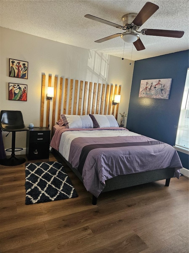 bedroom featuring hardwood / wood-style floors, a textured ceiling, and ceiling fan