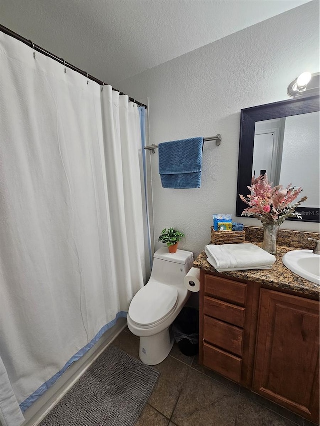 bathroom with vanity, toilet, tile patterned floors, and a textured ceiling