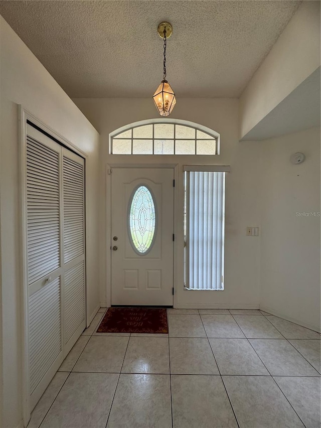 tiled foyer entrance featuring a textured ceiling