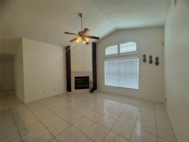 unfurnished living room featuring light tile patterned flooring, a textured ceiling, a tile fireplace, ceiling fan, and vaulted ceiling