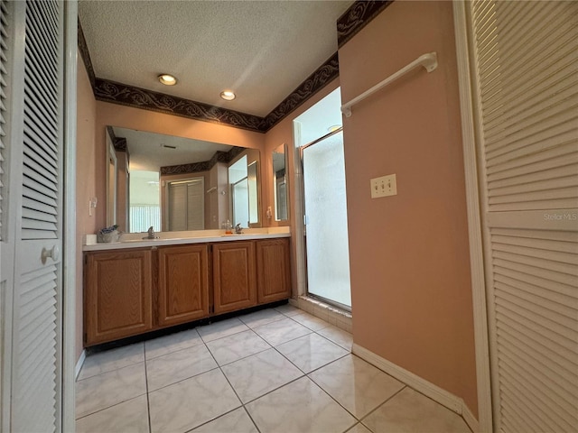 bathroom featuring vanity, tile patterned flooring, a textured ceiling, and walk in shower