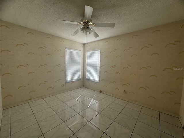 tiled empty room with a textured ceiling and ceiling fan