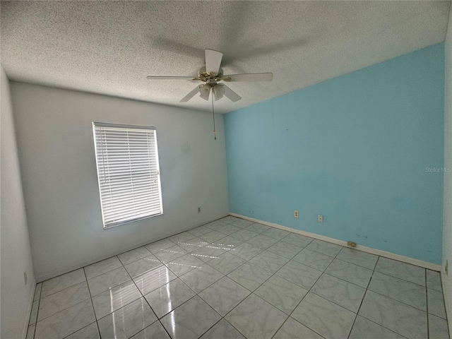 empty room with a textured ceiling, light tile patterned floors, and ceiling fan