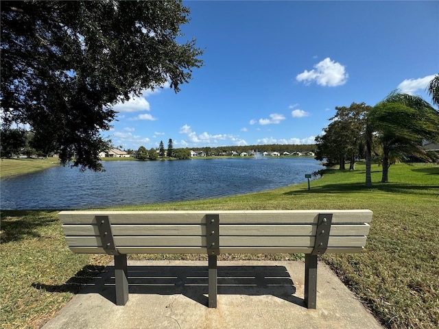 surrounding community featuring a water view and a lawn