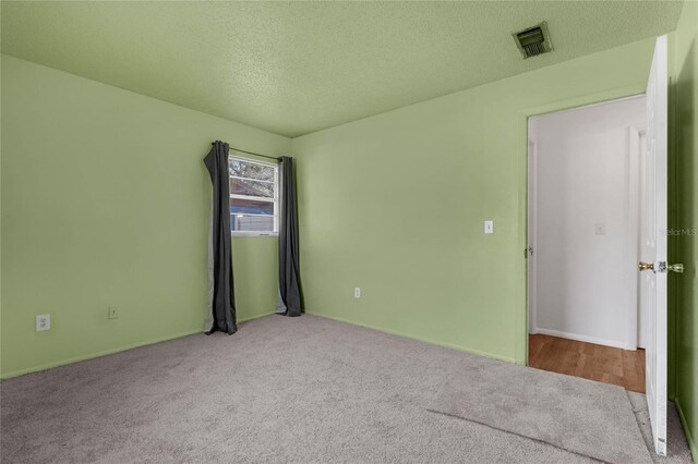 2319 Continental Blvd, Orlando, FL 32808 - empty room with carpet floors, a textured ceiling, baseboards, and visible vents