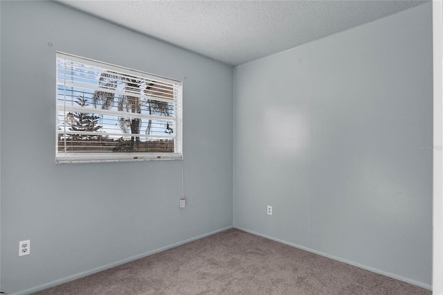 carpeted spare room featuring a textured ceiling