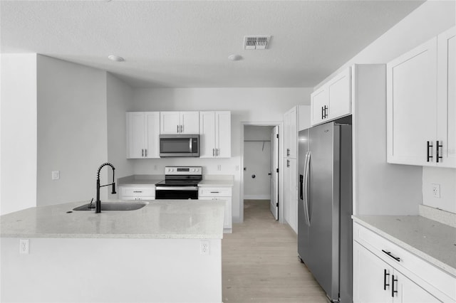 kitchen with white cabinetry, light stone countertops, light hardwood / wood-style flooring, sink, and stainless steel appliances