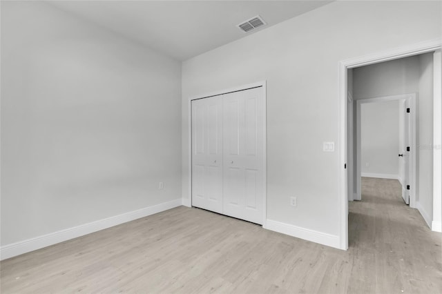 unfurnished bedroom with a closet and light wood-type flooring