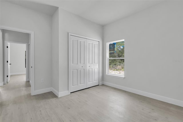 unfurnished bedroom featuring a closet and light hardwood / wood-style floors