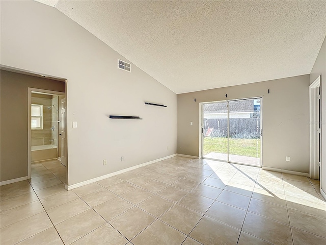 tiled spare room featuring a textured ceiling and high vaulted ceiling