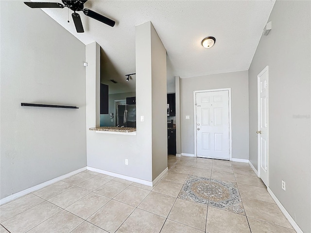 tiled foyer with ceiling fan and a textured ceiling