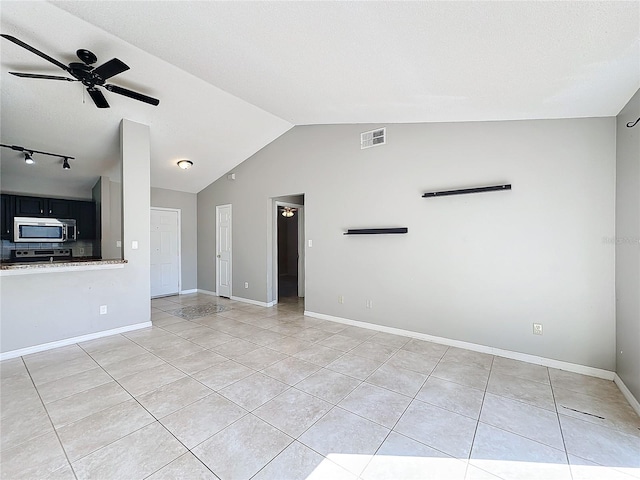 unfurnished living room featuring light tile patterned floors, vaulted ceiling, and ceiling fan