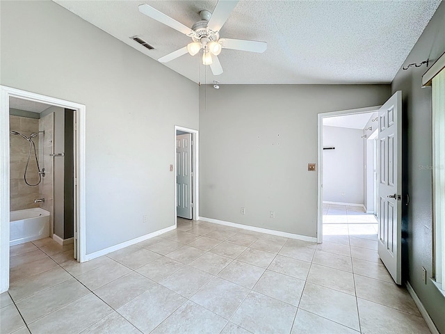 unfurnished bedroom featuring light tile patterned floors, connected bathroom, vaulted ceiling, and ceiling fan