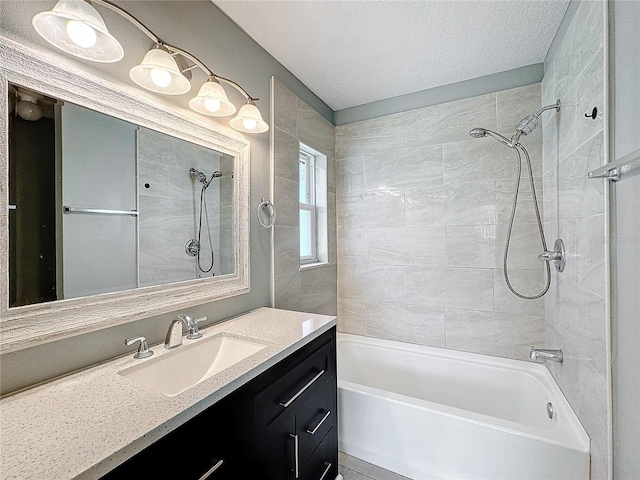 bathroom with vanity, tiled shower / bath combo, and a textured ceiling