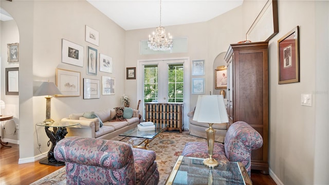 living area featuring french doors, a notable chandelier, and hardwood / wood-style floors