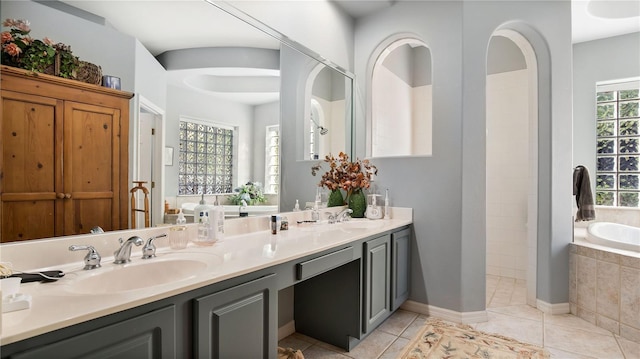 bathroom featuring vanity, tiled bath, and tile patterned floors