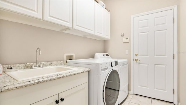 laundry area featuring sink, independent washer and dryer, cabinets, and light tile patterned floors