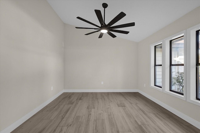 spare room featuring light hardwood / wood-style floors, vaulted ceiling, and ceiling fan