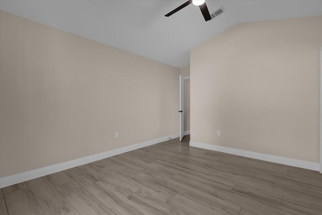 spare room with light hardwood / wood-style floors, vaulted ceiling, and ceiling fan