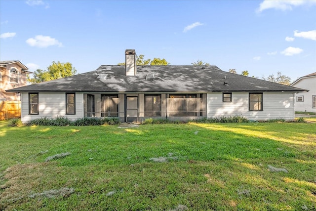 rear view of property with a lawn