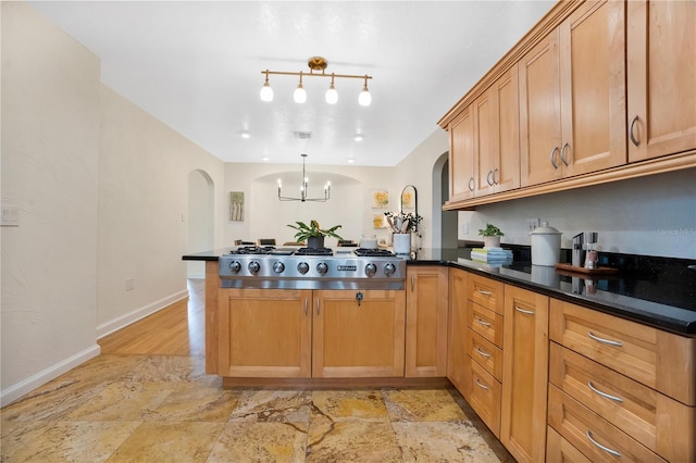 kitchen featuring an inviting chandelier, stainless steel gas cooktop, kitchen peninsula, pendant lighting, and light wood-type flooring